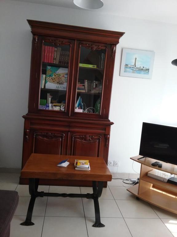 un gran armario de madera con una mesa delante en Maison bord de mer, en Penmarch