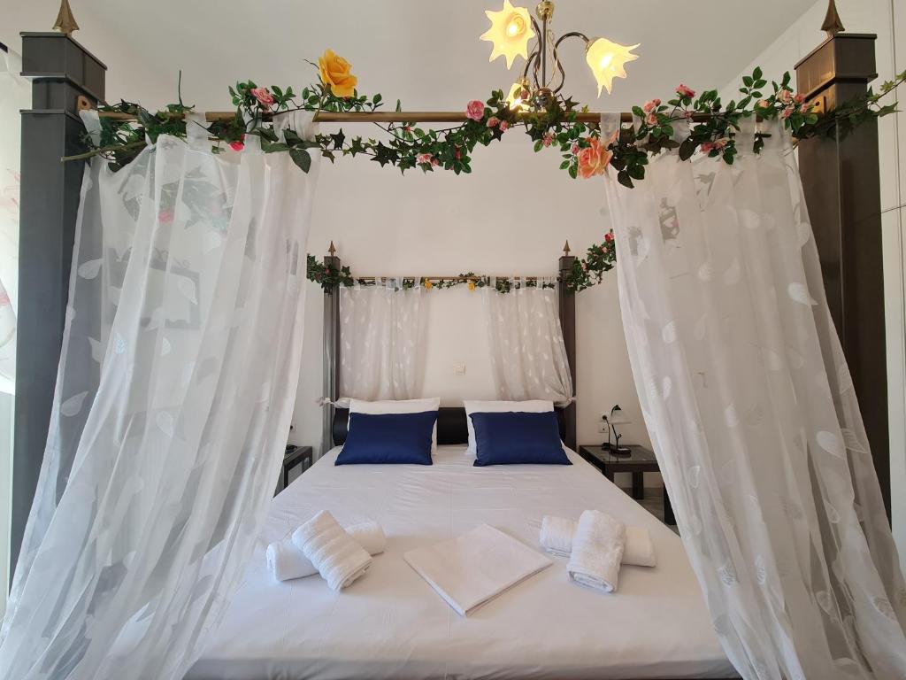 ein Schlafzimmer mit einem weißen Bett mit Baldachin in der Unterkunft Myrtia Guest House in Pýrgos