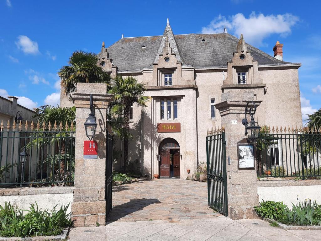 stary dom z bramą przed nim w obiekcie Hôtel De La Barbacane w mieście Tiffauges