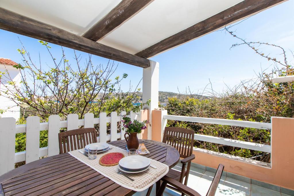 una mesa y sillas en el balcón de una casa en Tonina vista mare, en Capo Testa