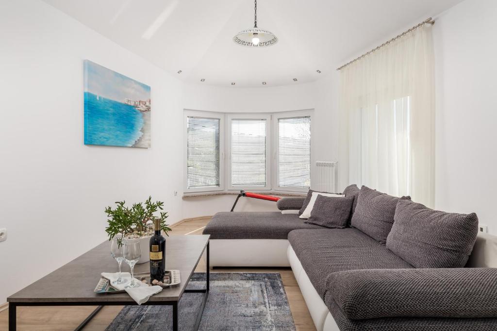 a living room with a couch and a table at Apartment DANI-E.L. in Kastav