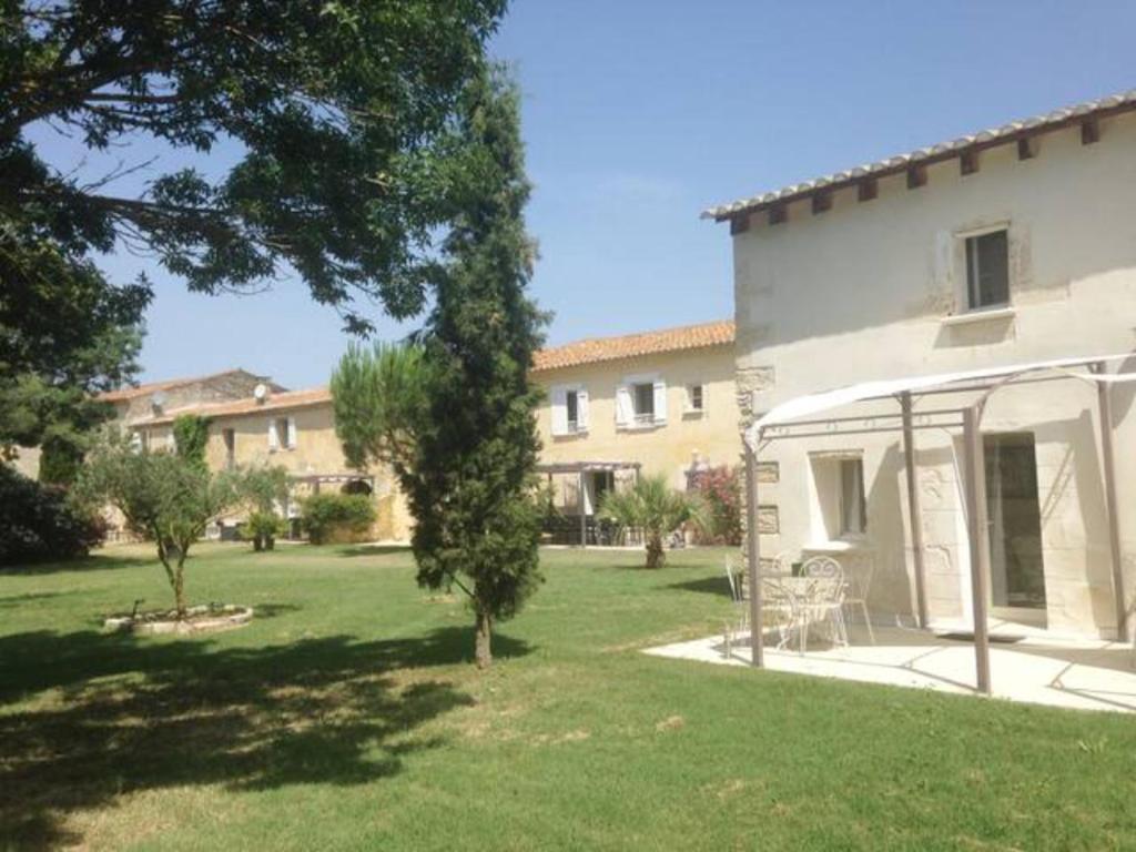 a house with a yard in front of a building at Les Templiers - Petit BIZERTY 36 pers (Mas privé) - 2 piscines - Salle 200 m² in Saint-Gilles