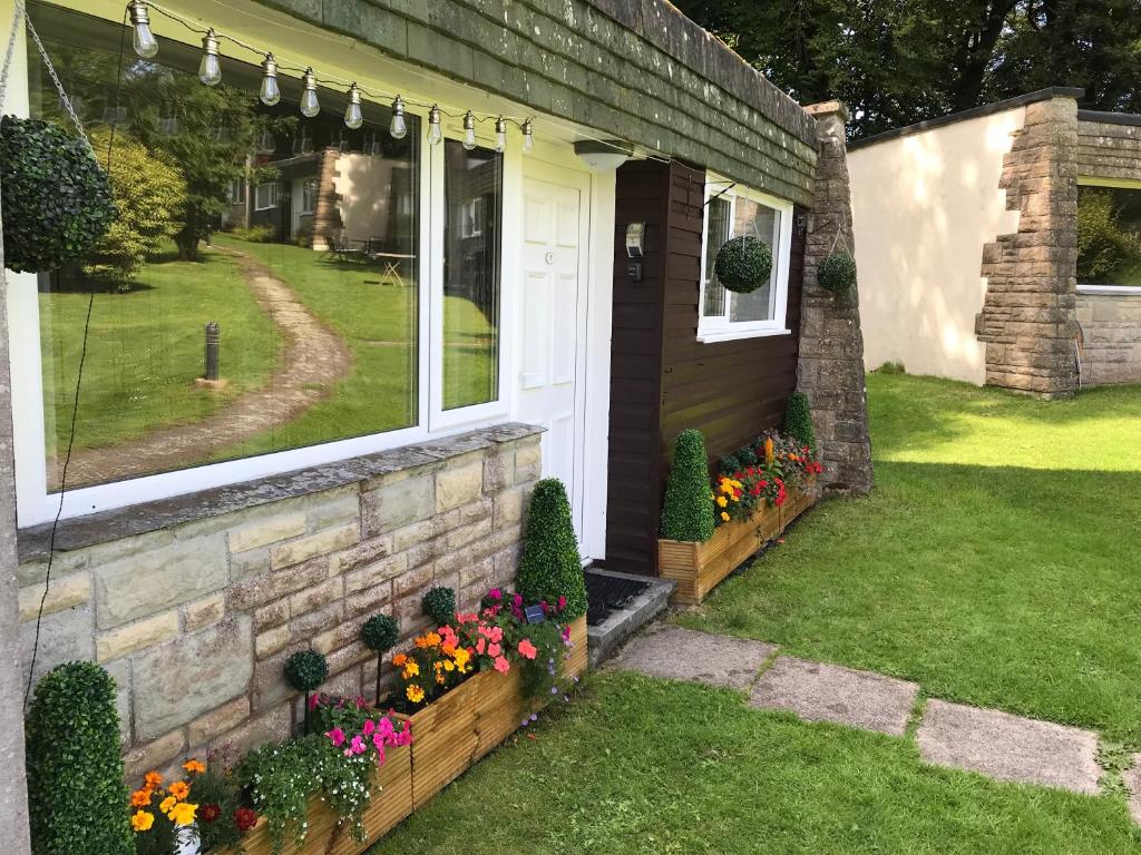 una casa con flores en el patio delantero en Villa 7 Lanteglos, Camelford, Cornwall en Camelford