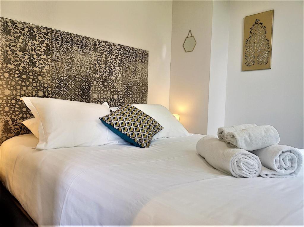 une chambre avec un lit blanc avec des serviettes dessus dans l'établissement Ruby, à Lyon