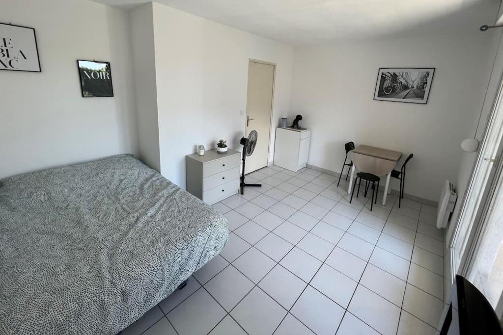 a bedroom with a bed and a table and chairs at Le Studio 36 à Nîmes, Wifi, Balcon in Nîmes