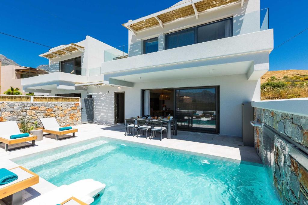 eine Villa mit einem Pool vor einem Haus in der Unterkunft Villa Smili-Naiades/3 bedrooms, luxury, beachfront in Plakias