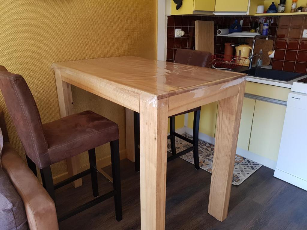 une table en bois et une chaise dans la cuisine dans l'établissement 20ml du port, au Pouliguen