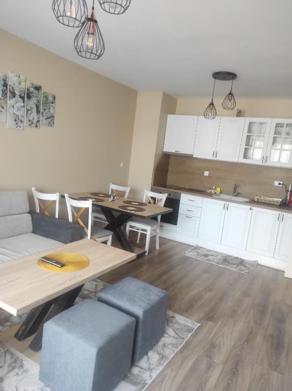 a kitchen and living room with a table and a couch at Апартамент Четири сезона 2 in Velingrad