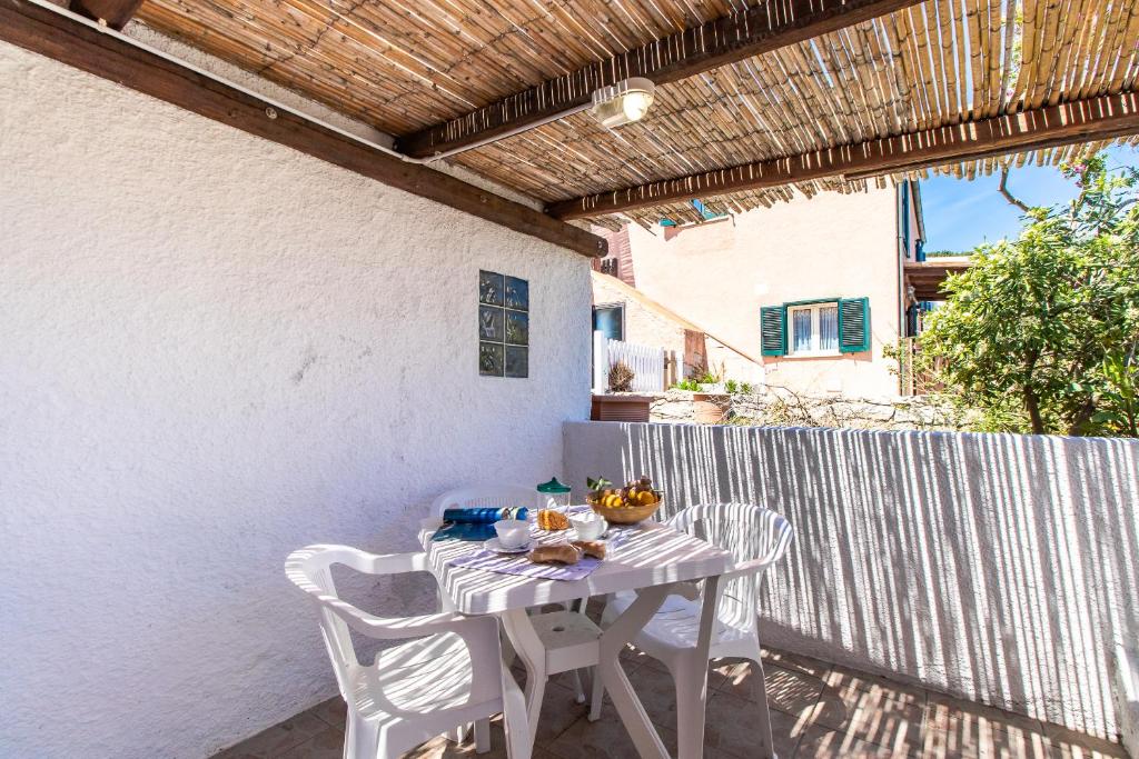 - une table et des chaises blanches sur la terrasse dans l'établissement Salvatore, à Capo Testa