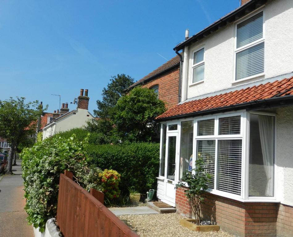 Casa blanca con ventana y valla en Mabel Cottage Sheringham, en Sheringham