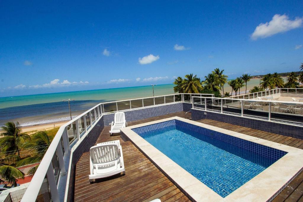 una piscina en una terraza junto a la playa en Bela Hospedagem - At Sul - Flat com vista para o mar a 80m do Bar do Cuscuz, en João Pessoa