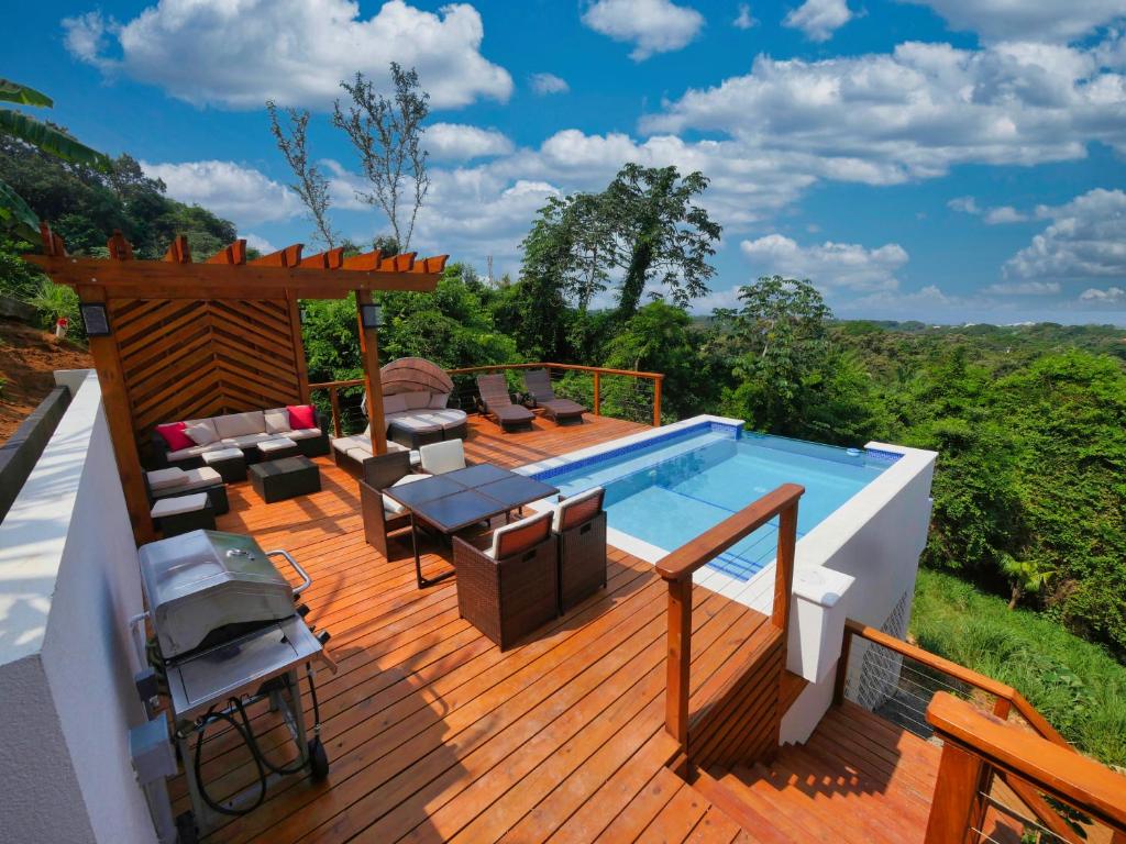 a deck with a pool and a table and chairs at Sandy Feet Retreat in Sandy Bay