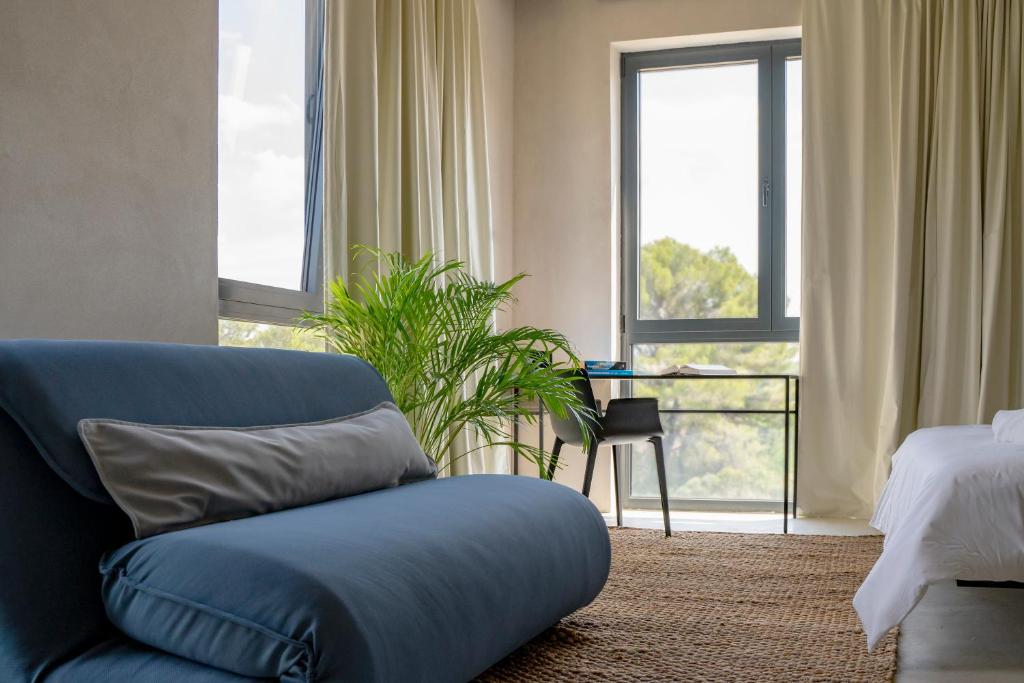 a living room with a blue couch and a bed at Moro Inn in Korčula