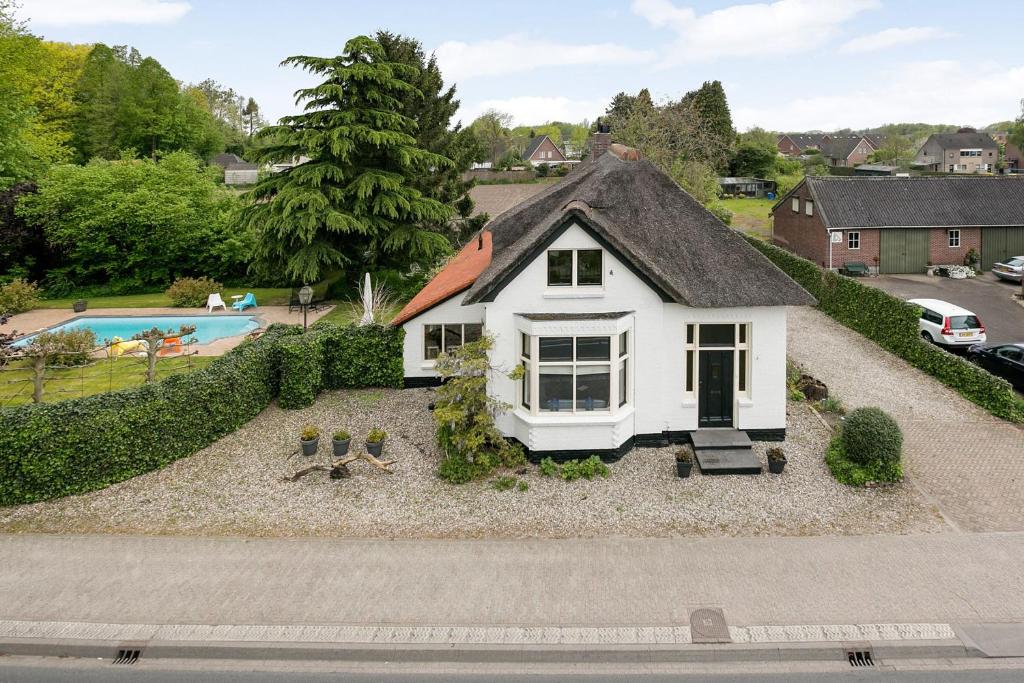 una piccola casa bianca con tetto nero di het opgemaakte bed a Haps
