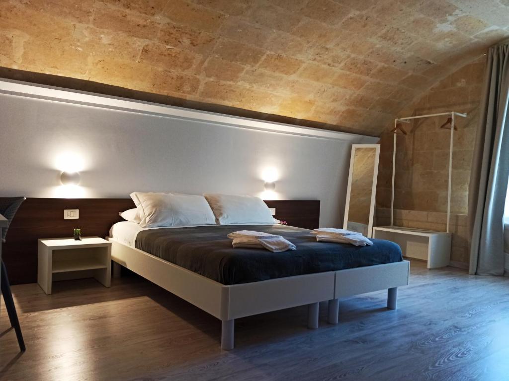 ein Schlafzimmer mit einem großen Bett und einer Dusche in der Unterkunft In & Out Matera in Matera
