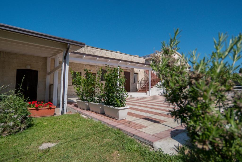 uma casa com um pátio com vasos de plantas em Agriturismo Le Matinelle em Matera