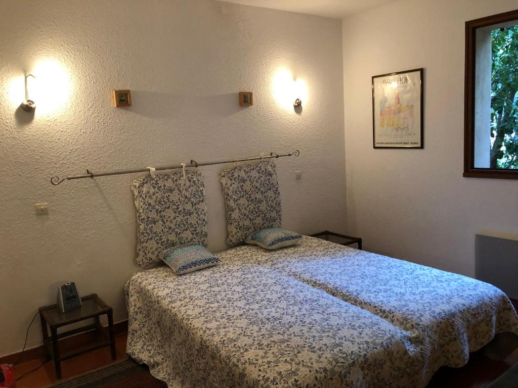 um quarto com uma cama com duas almofadas em Villa avec piscine au Lavandou dans jardin méditerranéen em Le Lavandou