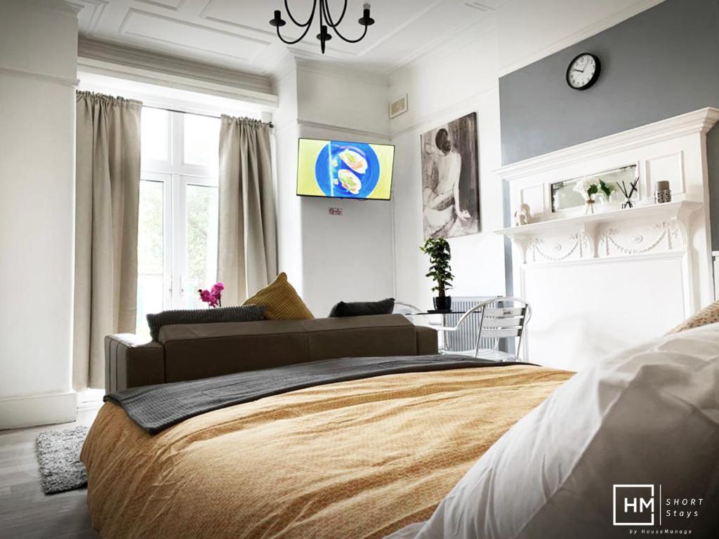 1 dormitorio con 1 cama y reloj en la pared en Norbury House - Apratment 1b en Norbury