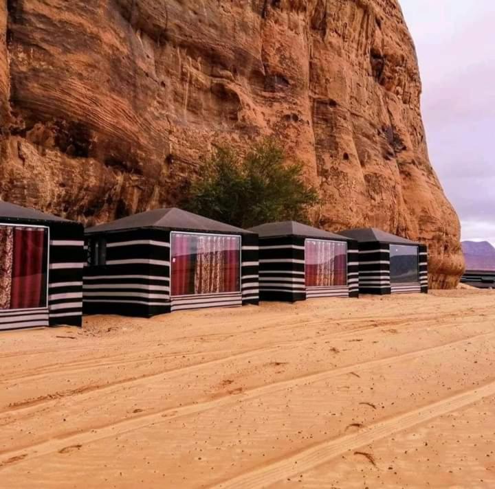 una fila de edificios en el desierto cerca de una montaña en Shahrazad desert, Wadi Rum, en Wadi Rum