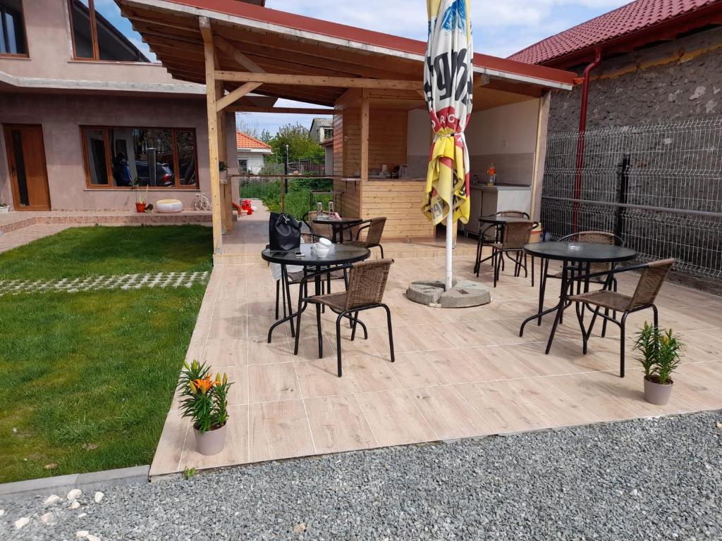 a patio with tables and chairs and a flag at Casa Ella in 2 Mai