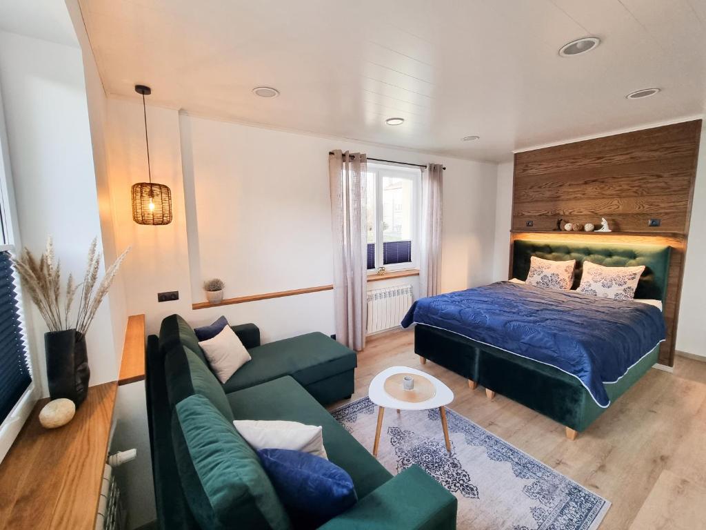 uma sala de estar com uma cama e um sofá em Kristella Kesklinna Apartment em Haapsalu