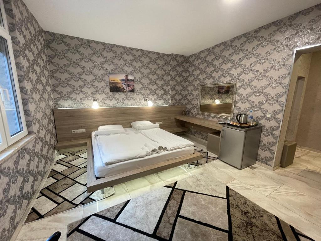 a bedroom with a bed and a desk in it at De Luxe Studio Burgas, City Center in Burgas City