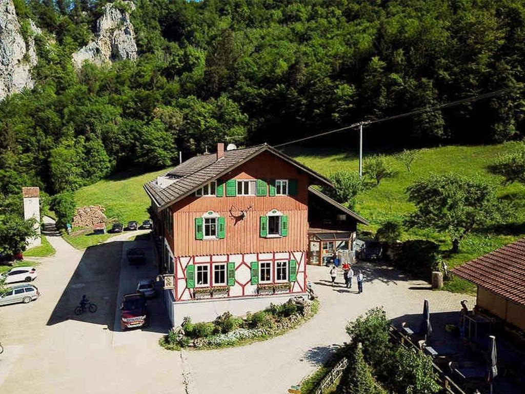 a large wooden house in front of a mountain at Gasthaus Jägerhaus in Fridingen an der Donau