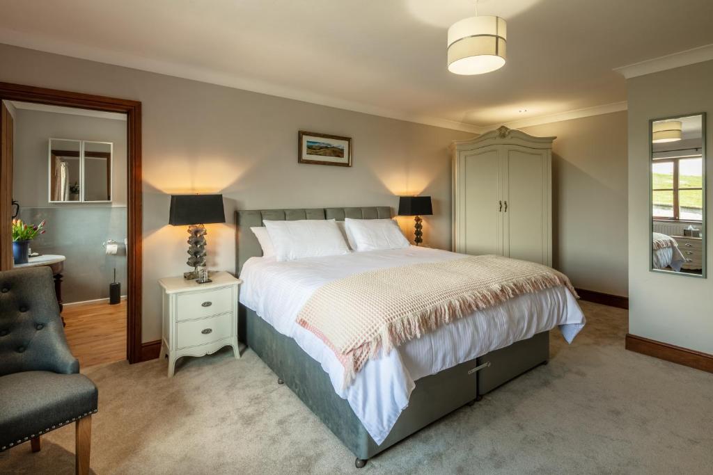 a bedroom with a large bed and a chair at Beaconsview B&B in Brecon