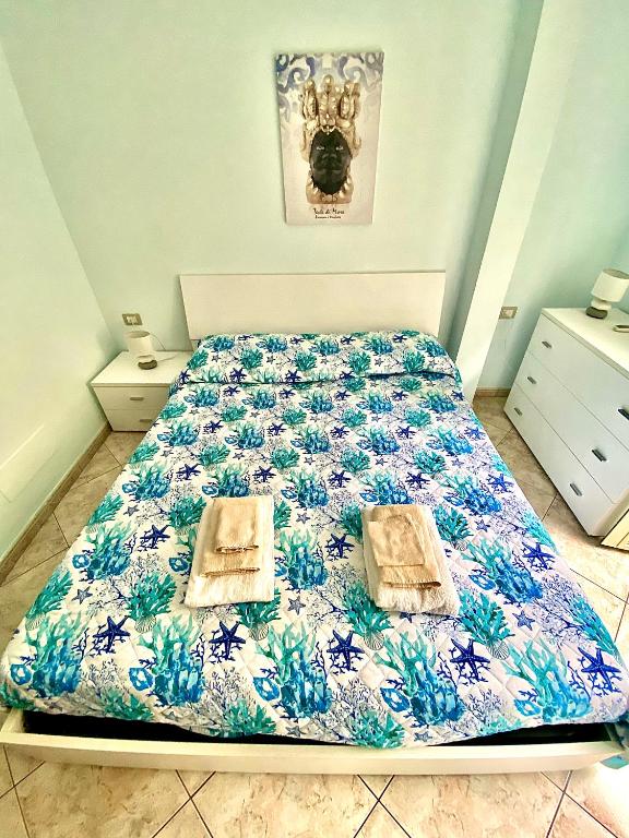 a bedroom with a bed with a blue and white comforter at La casa del pescatore in Scilla