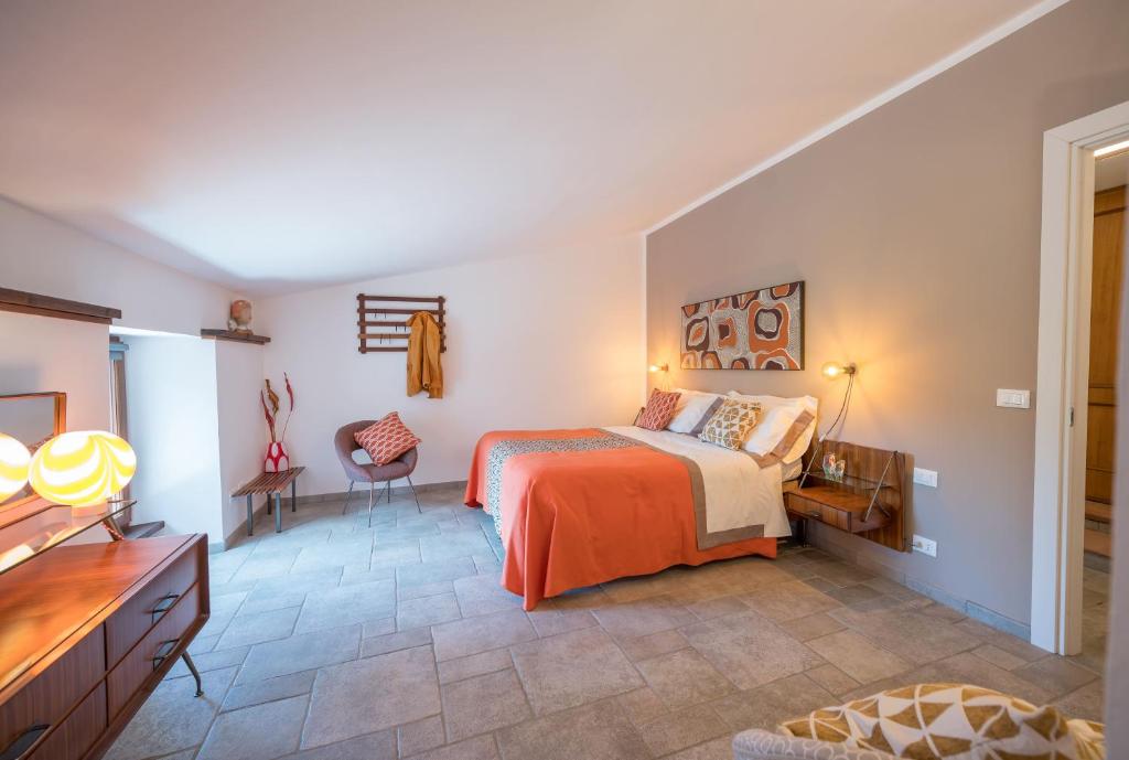 a bedroom with a bed and a desk and chair at Cascina Gazzeri Country House in Tagliolo Monferrato