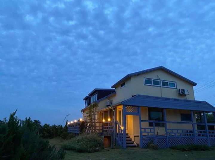 a house sitting on top of a field at Warang Guesthouse in Jeju