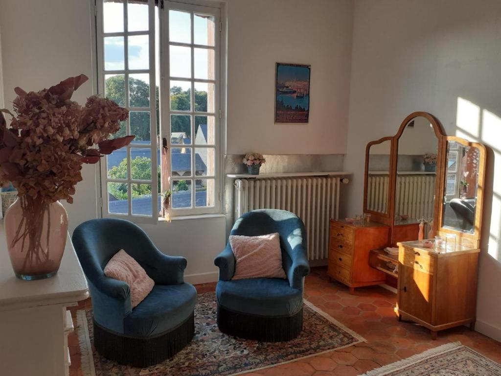 a living room with two chairs and a table at Maison d'Hôtes Archangels Home in Saint-Saëns