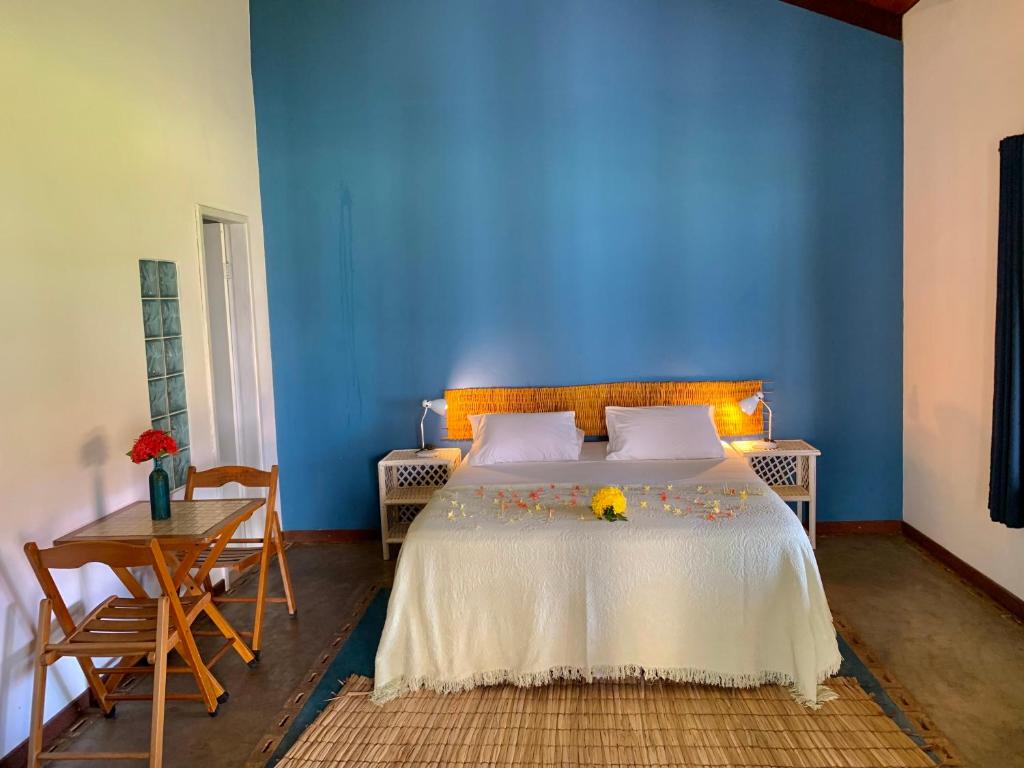 um quarto azul com uma cama com flores em Pousada Maraú em Marau