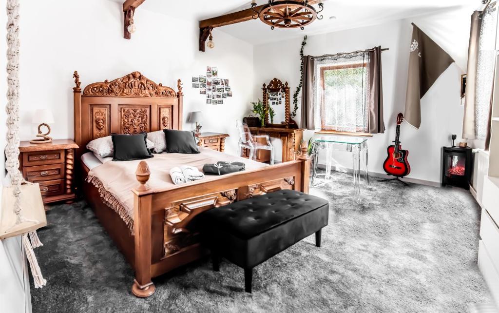 een slaapkamer met een bed, een bureau en een gitaar bij Stylowy apartament w historycznej części Gdańska in Gdańsk