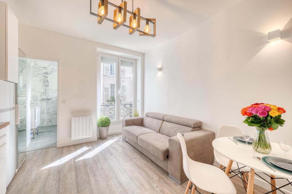 a living room with a couch and a table at HR Rambuteau - Châtelet in Paris