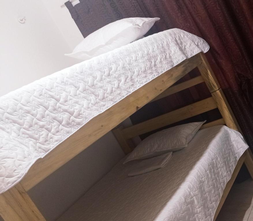 Litera con colchón blanco y almohadas en Enjoy Colombia Hostel, en Villavicencio
