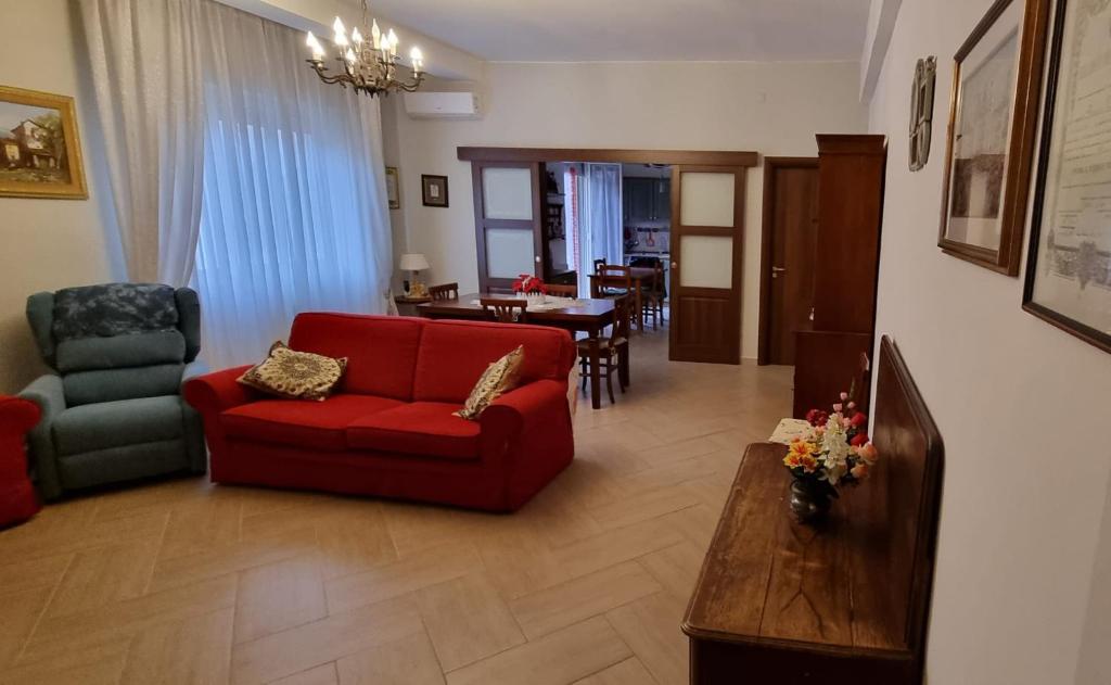 sala de estar con sofá rojo y mesa en Casa Lucia, en Siracusa