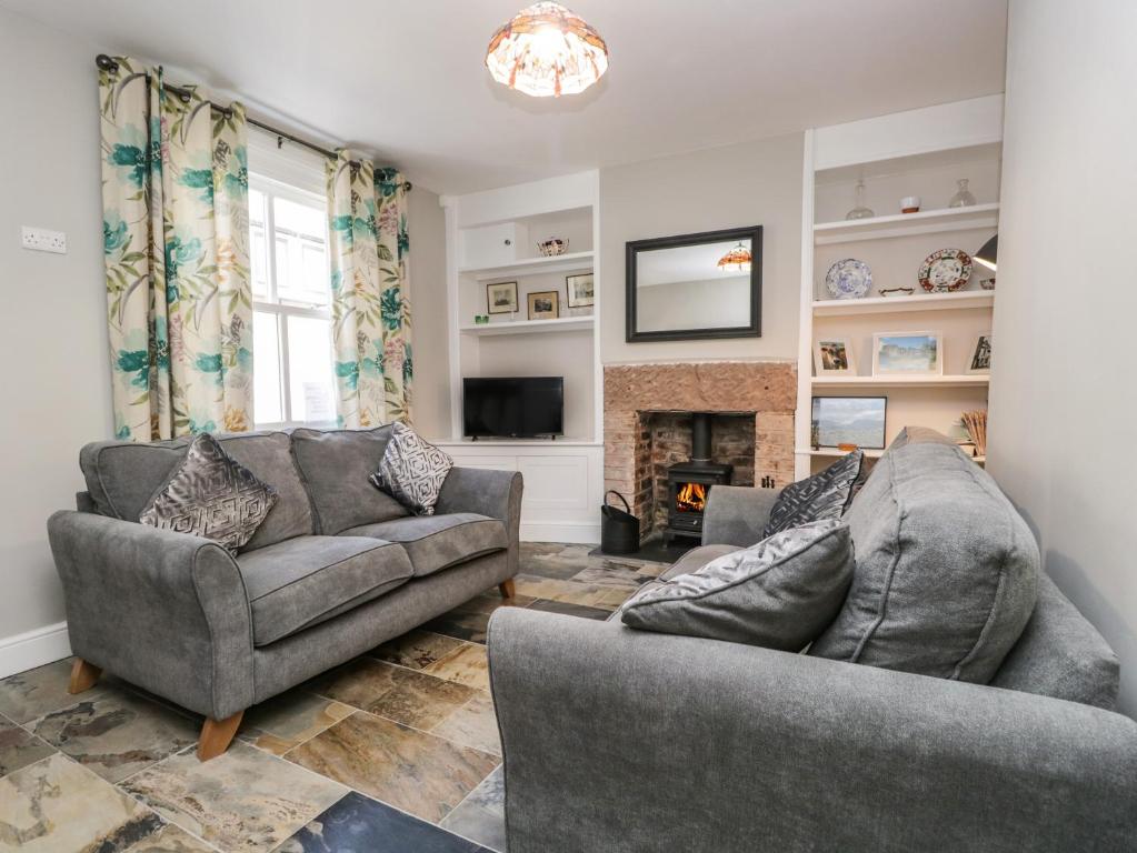 uma sala de estar com dois sofás e uma lareira em No 2 Waterloo Street em Cockermouth