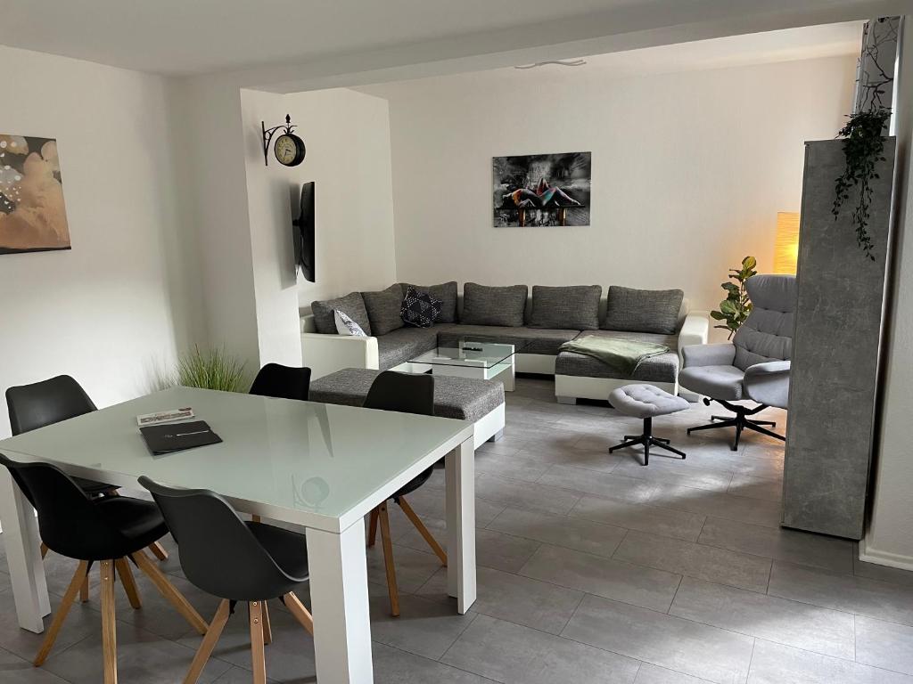 - un salon avec une table et des chaises blanches dans l'établissement Große moderne Ferienwohnung, ruhige Innenstadtlage, à Cassel