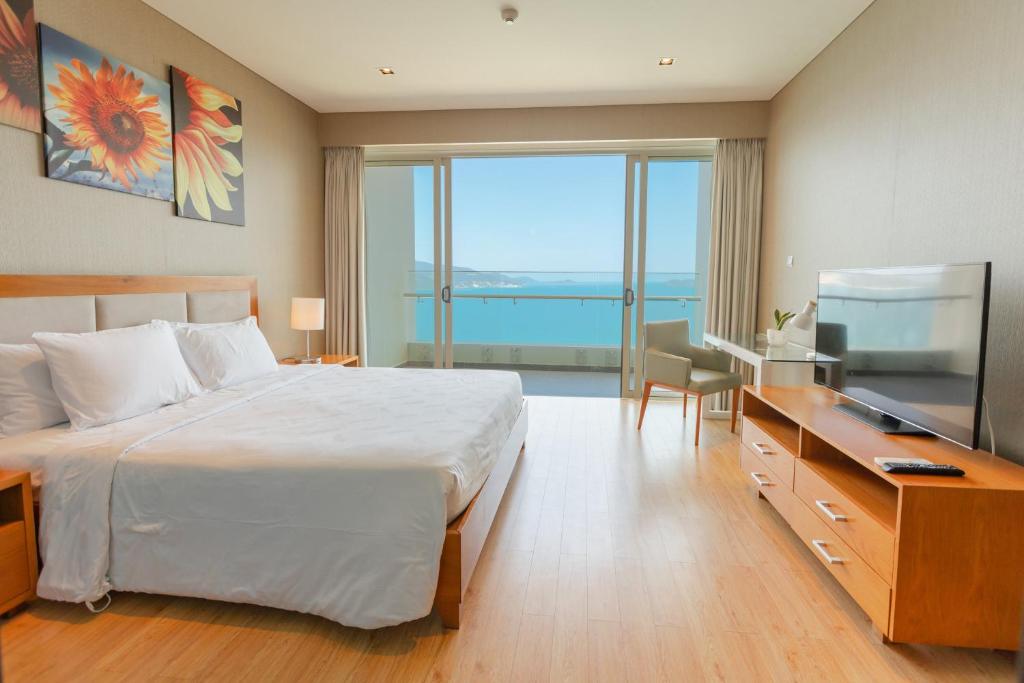 a bedroom with a bed and a desk with a computer at Sea View Luxury - Apartments in Nha Trang