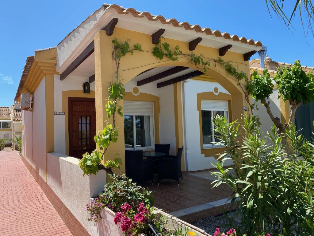 une maison avec une arche et des fleurs devant elle dans l'établissement Casa Montana tranquilidad en la Costa Cálida, à Mazarrón