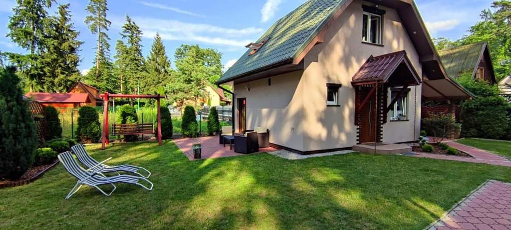 a yard with a chair and a house at Nad Miedwinką - Dom in Morzyczyn