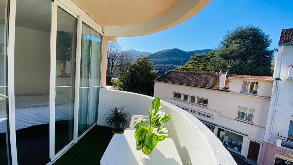 balcón con mesa y vistas a un edificio en Superbe appart avec de parking gratuit sur place, en Lourdes