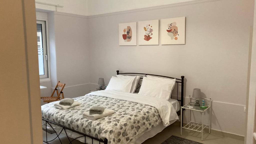 1 dormitorio con 1 cama con 2 toallas en Chris AKROPOLI, en Atenas