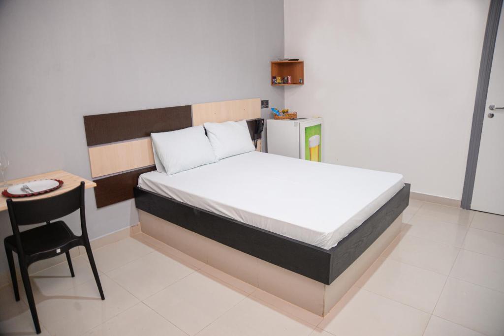 Un dormitorio con una cama, una mesa y una silla. en Nidore Motel, en Boa Vista
