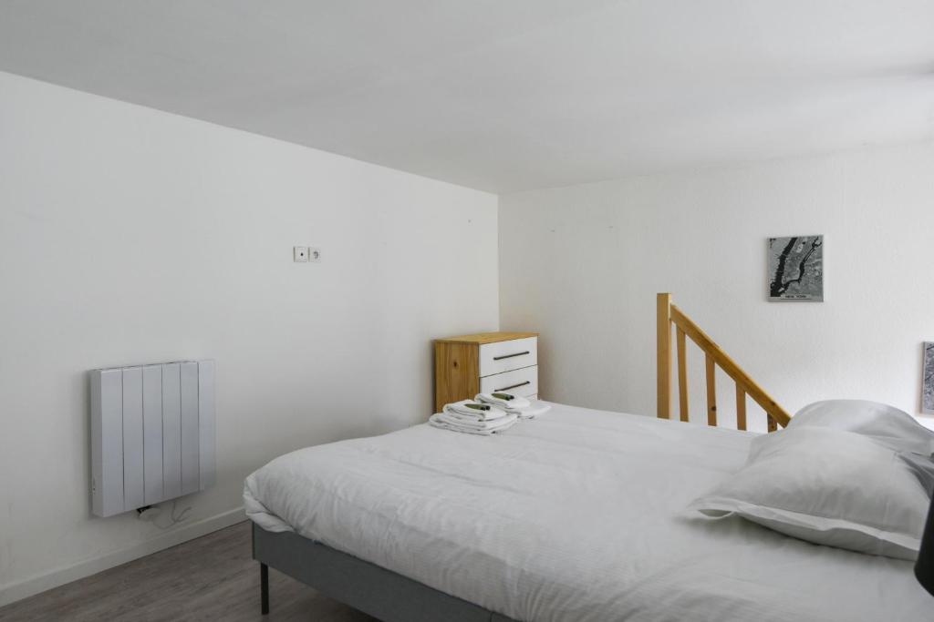 a white bedroom with a bed and a radiator at Large and calm flat in the heart of Lille - Welkeys in Lille