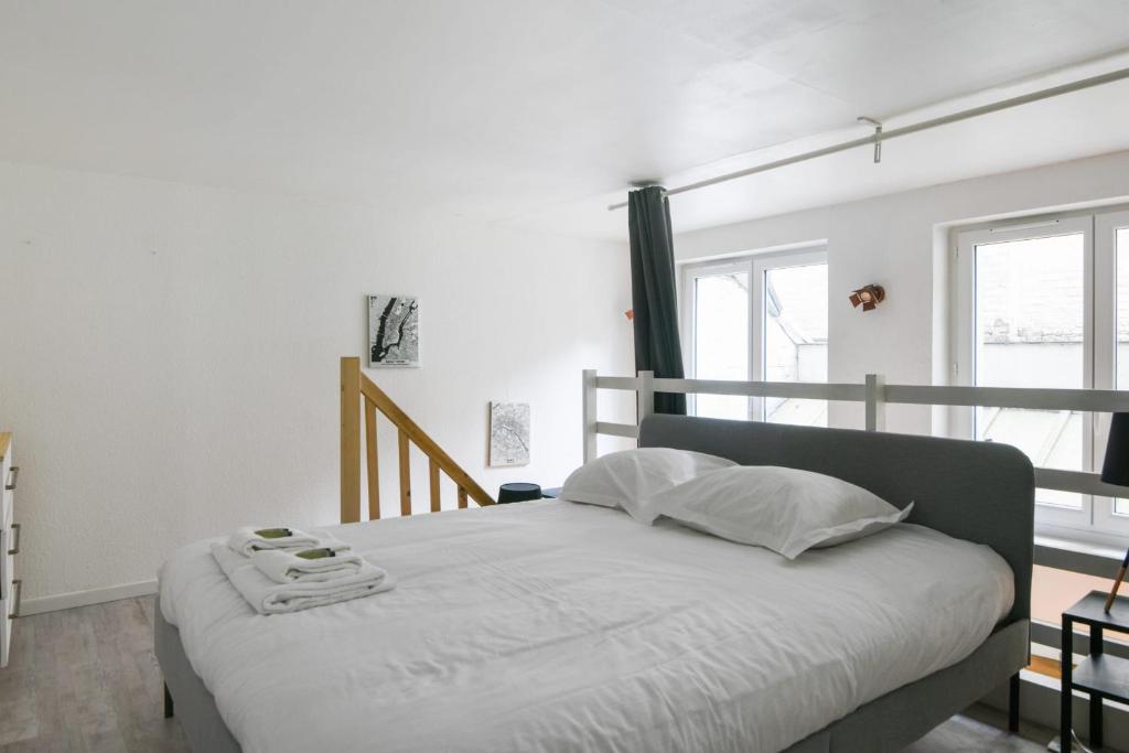 a bedroom with a bed with white sheets and pillows at Large and calm flat in the heart of Lille - Welkeys in Lille