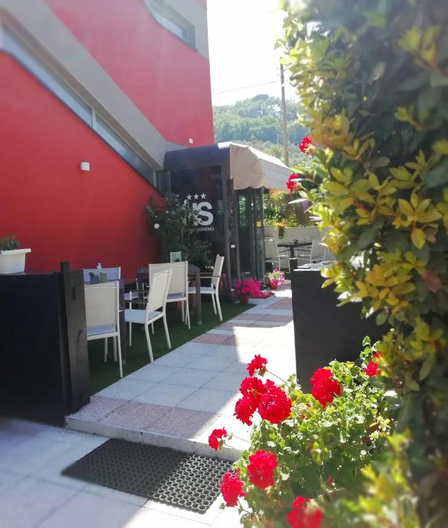 a restaurant with tables and chairs and red flowers at Hotel Sereno in Sestri Levante