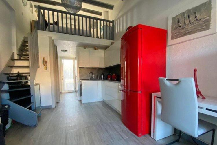 Cette chambre comprend une cuisine équipée d'un réfrigérateur rouge. dans l'établissement Villa Village Naturiste Cap d'Agde, au Cap d'Agde