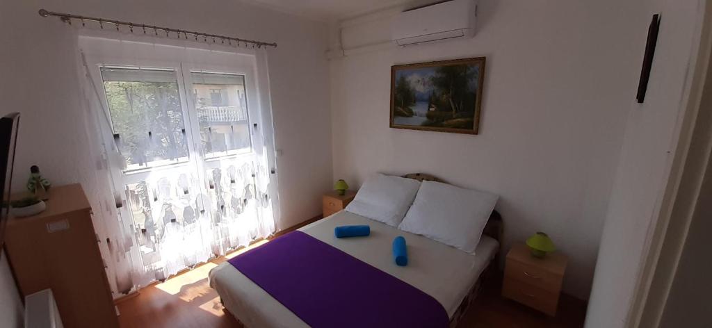Habitación pequeña con cama y ventana en Major apartman en Kehidakustány